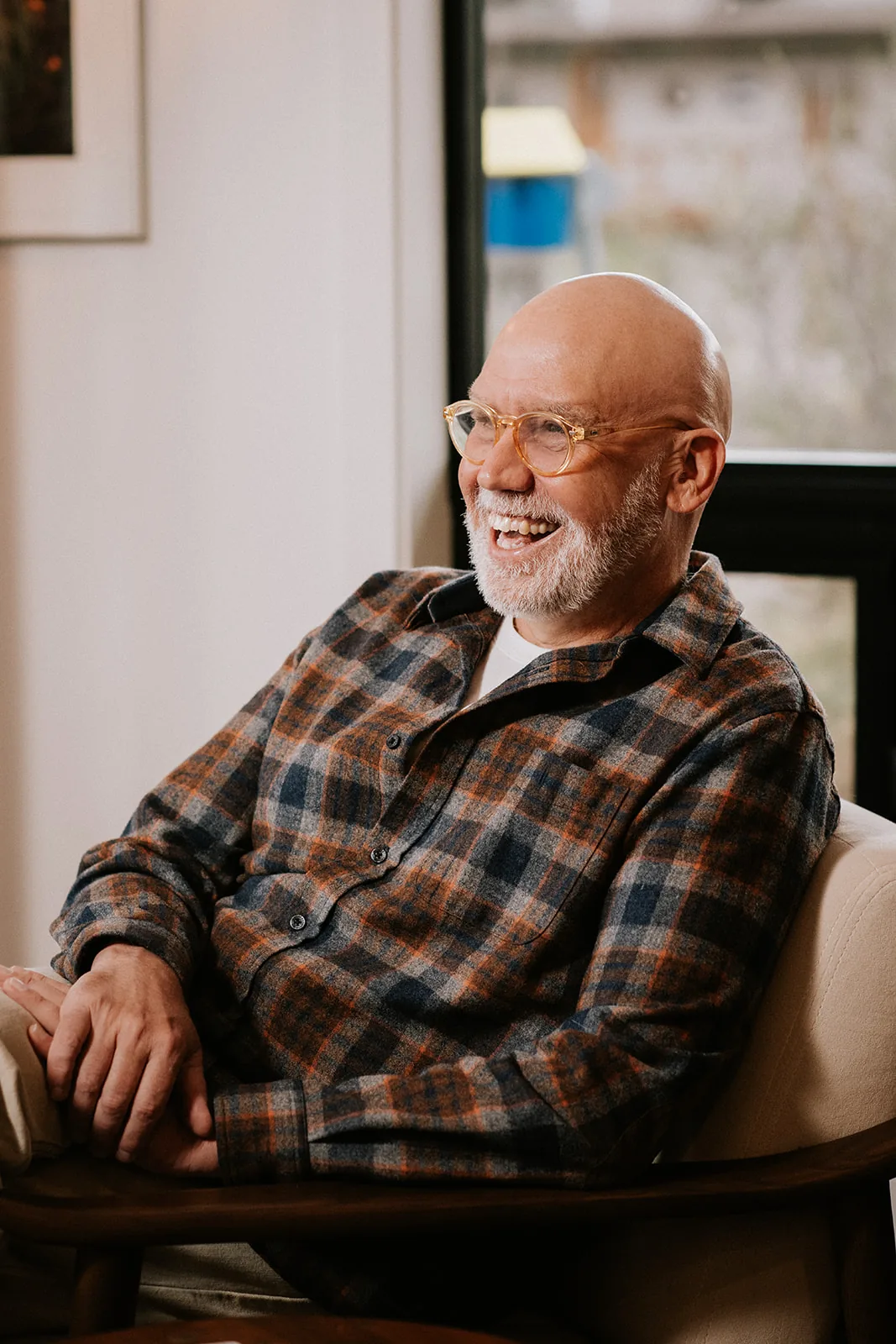 Mike Remshard laughing, seated in a chair in his office
