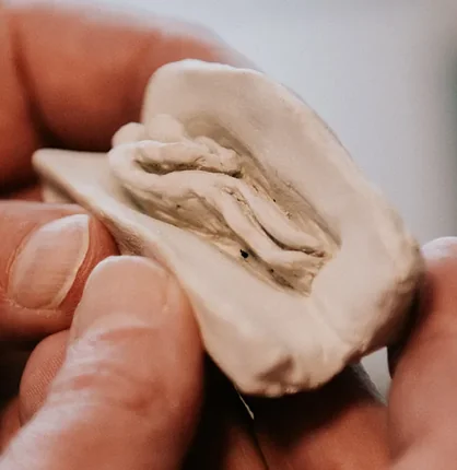 Hands holding a piece of shaped clay