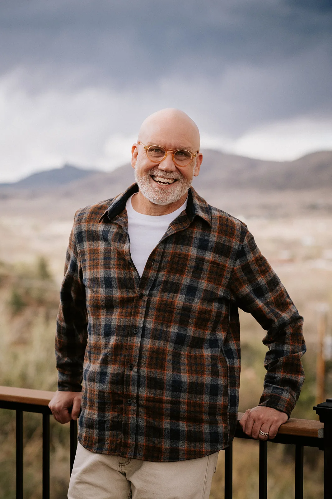 Mike Remshard smiling, leaning on a railing outdoors in Colorado